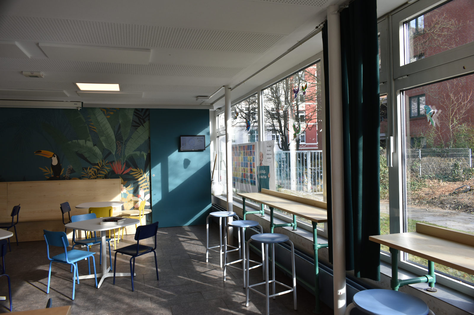 Fensterplätze mit Hochtischen und Hockern in einer Schulmensa mit Blick nach draußen