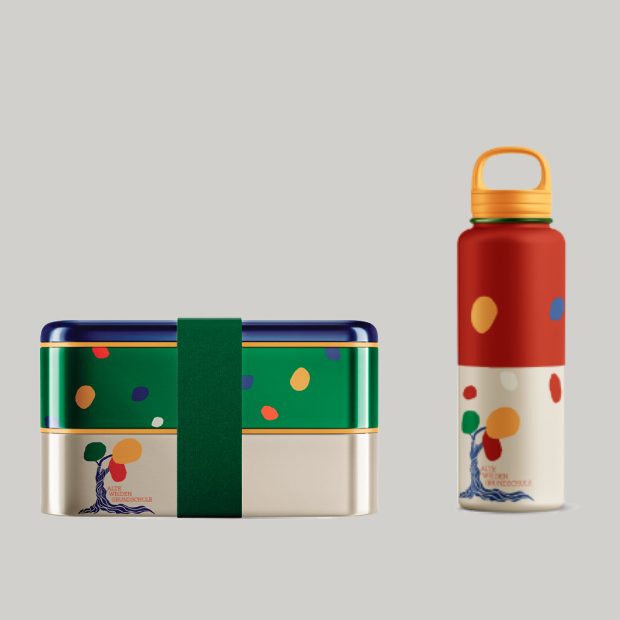 Das neue Corporate Design findet auch auf Alltagsgegenständen Anwendung: Brotdose und Trinkflasche machen die Gestaltung im Schulalltag sichtbar und erlebbar Merchandising-Produkte der Grundschule: eine Trinkflasche und eine Brotdose mit Gestaltungselementen des neuen Corporate Designs