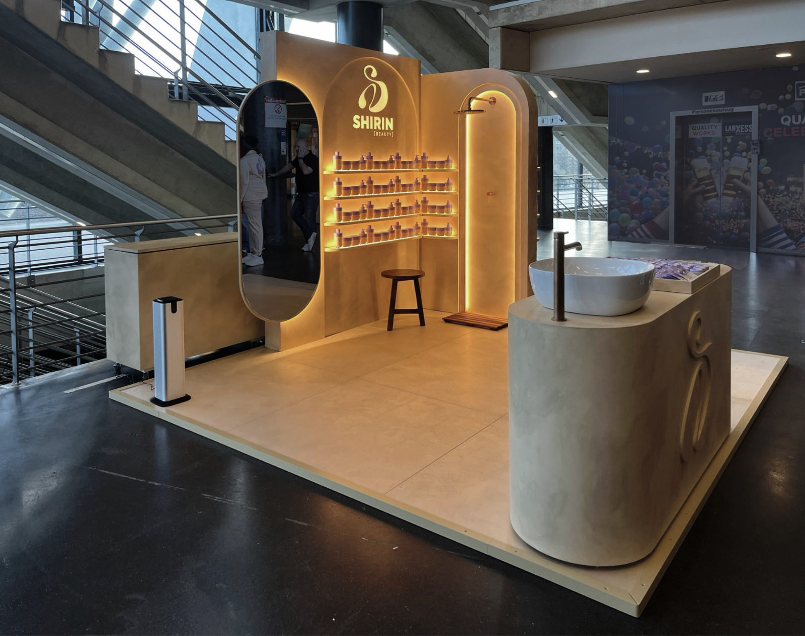 Foto des aufgebauten Promotionstands von Shirin Beauty während der Konzerttour – mobiles Standdesign mit Waschplatz und Rückwand in warmer Kalkputzoptik