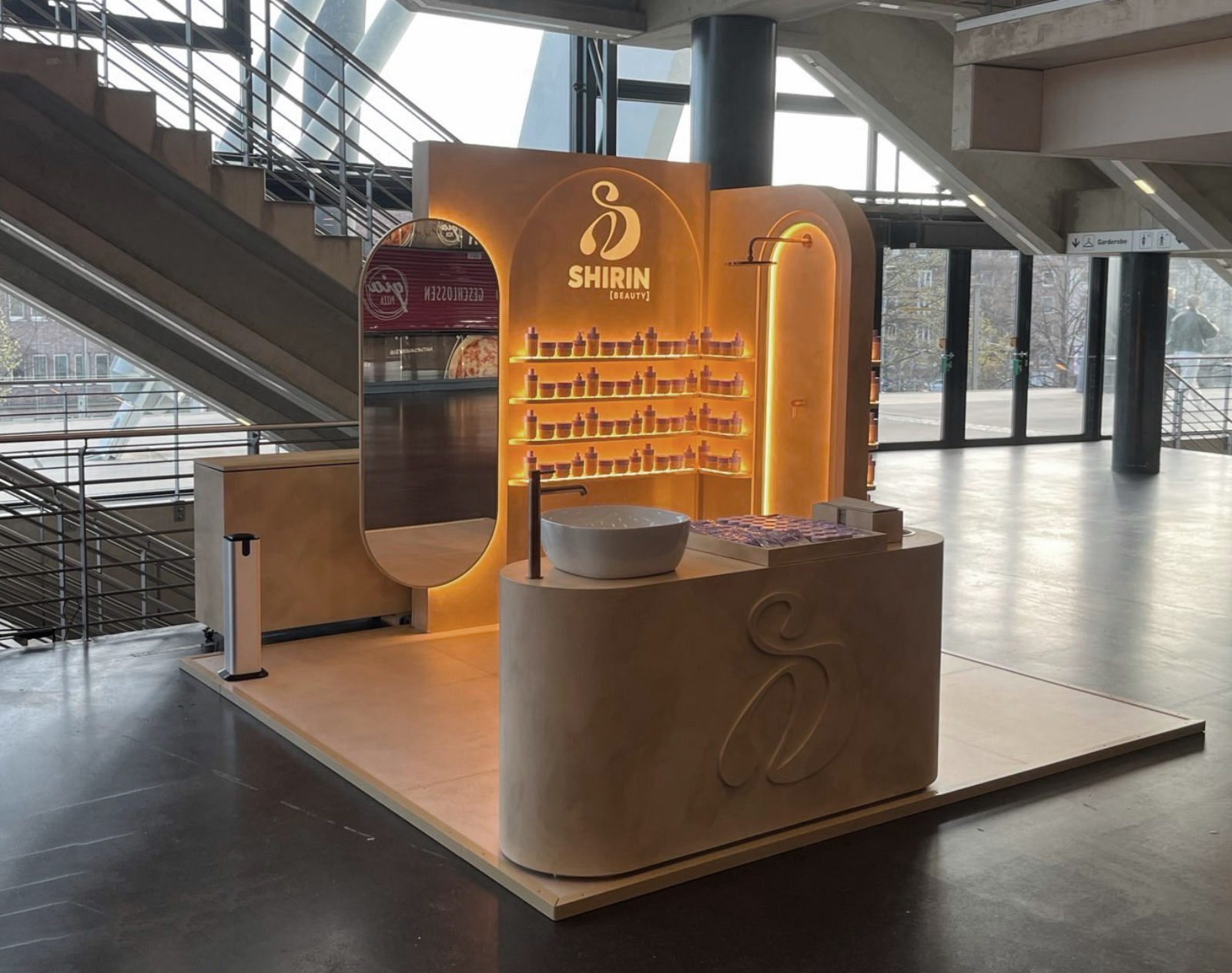 Foto des aufgebauten Promotionstands von Shirin Beauty während der Konzerttour – mobiles Standdesign mit Waschplatz und Rückwand in warmer Kalkputzoptik