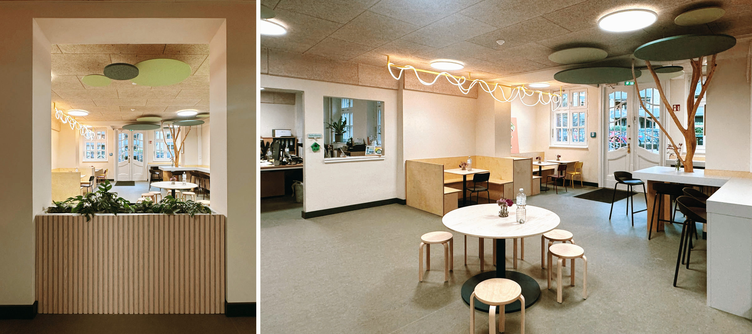 Mensa der Grundschule Isestraße mit zentralem Baumstamm, runden Akustikpaneelen in Grüntönen als abstrahierte Baumkrone, hölzernen Sitznischen und Pflanzkästen als Raumteiler.