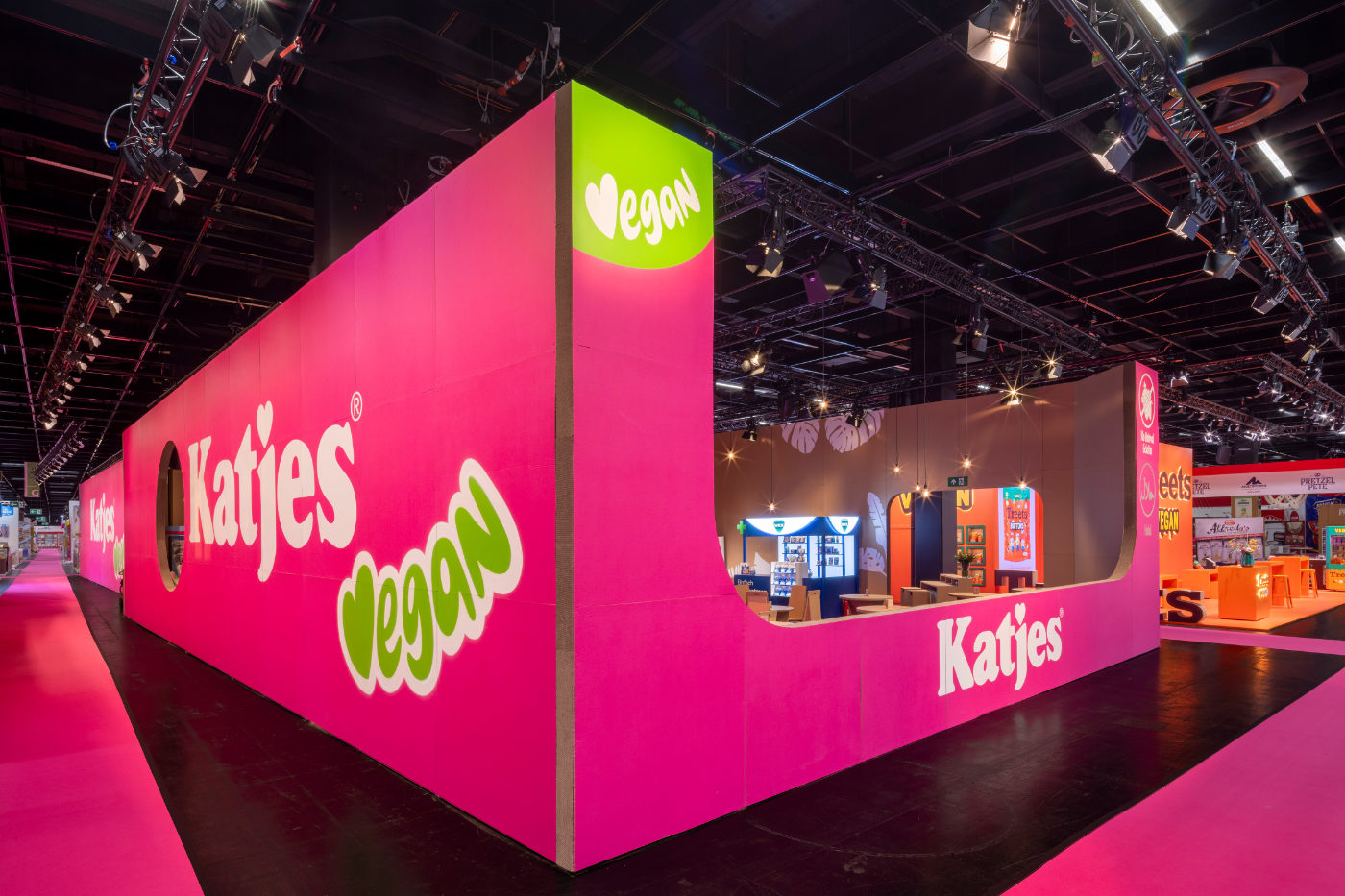 Pinkfarbene Außenfassade des Katjes-Messestands aus Pappe mit Katjes-Vegan-Schriftzug und offenem Einblick in den Stand