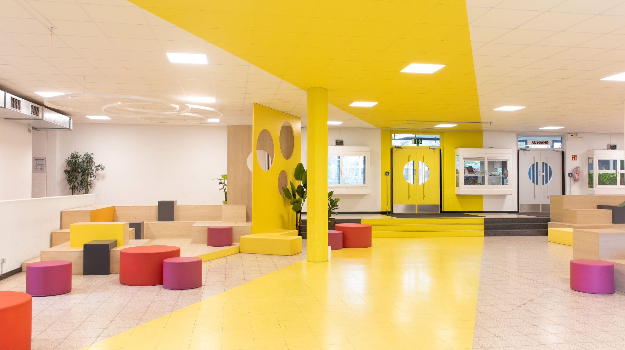 Gelb markierter Laufweg auf Boden und Decke zoniert die Pausenhalle der Otto-Hahn-Schule